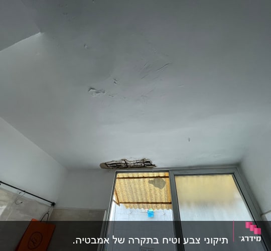 תקרת גבס עם סדקים ונזקי מים ליד חלון